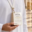 معتمر بلباس الإحرام يعلّق بطاقات دليل العمرة على رقبته بحبل ومشبك