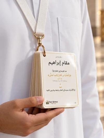 معتمر بلباس الإحرام يعلّق بطاقات دليل العمرة على رقبته بحبل ومشبك